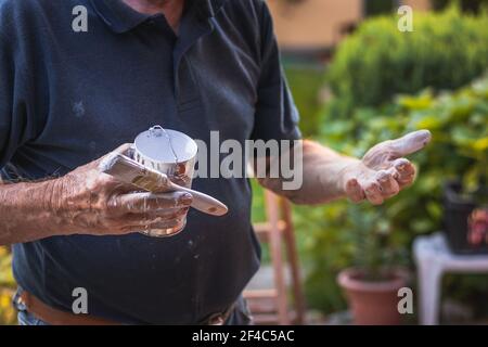 Senior Handwerker hat eine schmutzige Hände nach dem Malen. Alter Mann mit Pinsel. Stockfoto