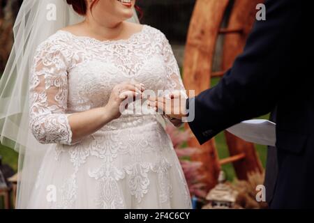 Nahaufnahme von schönen Paar auf Eheringe, schöne weiße Frau mit schönen afroamerikanischen Mann stehen in der Nähe dekorierten Bogen, Hochzeit Stockfoto