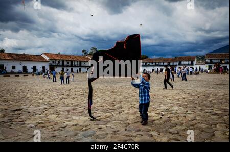 Ein kleiner Junge startet seinen Drachen in Villa de Leyva, Kolumbien. August ist Drachenflieger-Saison in Kolumbien. Stockfoto