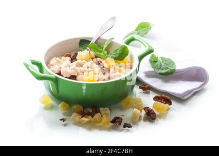 Gekochte gekochte süße Haferflocken mit Nüssen und kandierten Früchten in Eine Schüssel isoliert auf weißem Hintergrund Stockfoto
