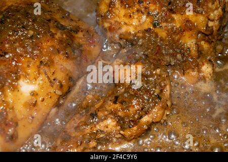 Kleine Stücke Hühnerfleisch werden mit Gewürzen geschmort. Nahaufnahme mit selektivem Fokus. Stockfoto