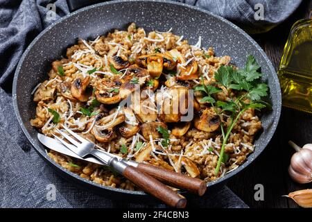 Klassisches cremiges Pilzrisotto mit geriebenem Parmesan in einer Pfanne, Nahaufnahme, italienische Küche Stockfoto