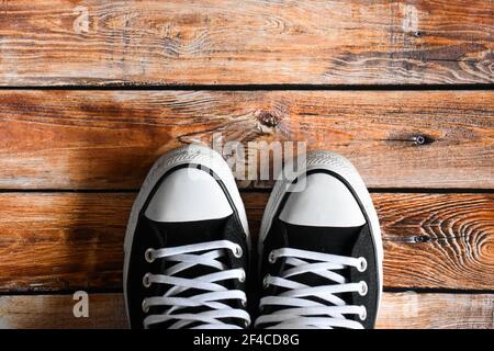 Schwarze Turnschuhe auf einem Holzboden Stockfoto