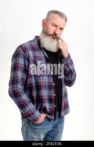 Studio Porträt von nachdenklichen reifen bärtigen Mann in Jeans und karierten Hemd gekleidet, Blick besorgt, Denken über Probleme, weißer Hintergrund Stockfoto