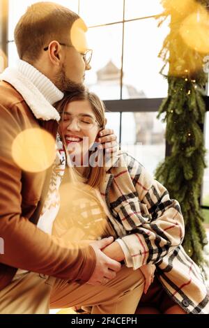 Schöne junge Paar kuscheln zu Hause, liebenswert Frau lächeln, genießen Sie zärtliche Momente, festliche Weihnachtsstimmung, Silvester Feier, Gemütlicher Winterurlaub Stockfoto