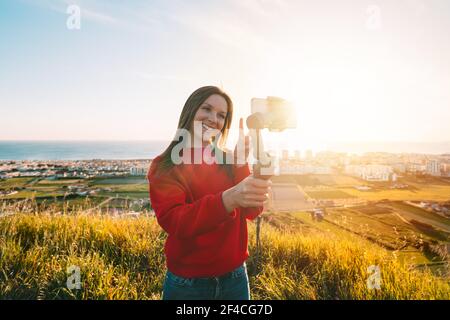 Frau mit Gimbal mit Telefon und Selfie oder Live-Streaming. Bloggen Stockfoto