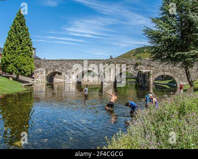 Junge Pilger baden im Fluss vor der römischen Brücke in Molinaseca, Spanien, 17. Juli 2010 Stockfoto