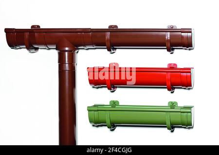 Kunststoffrinnen zum Ableiten von Wasser vom Dach des Hauses, braun, rot, grün. Downpipes, close-up, Kopierbereich. Stockfoto