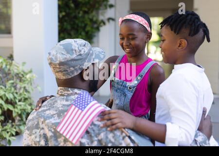 afroamerikanischer Soldat Vater Gruß lächelnd Sohn und Tochter in Vor dem Haus Stockfoto