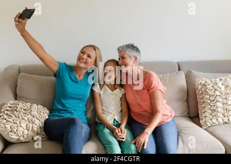 Kaukasische Mutter auf der Couch, Selfie mit lächelnden Tochter und Großmutter Stockfoto