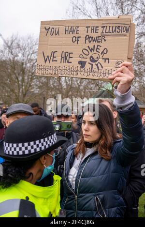 Westminster, London, Großbritannien. März 2021, 20th. In London ist ein protestmarsch gegen die Blockierung im Gange. Demonstranten versammelten sich im Hyde Park, bevor sie durch den Park marschierten und den Verkehr in der Park Lane und darüber hinaus blockierten. Junge Frau mit Plakat besagt, dass Sie die Illusion der Macht haben, Wir sind mächtig, mit Polizisten konfrontiert Stockfoto