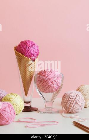 Pastellfarbene Garnkugel in einer Dessertschale und in einem Waffelkegel. Stockfoto