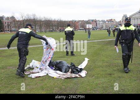 Amsterdam, Niederlande. März 2021, 20th. Niederländische Bereitschaftspolizei entfernt Transparente nach dem Aufbrechen eine illegale Demonstration von mehreren hundert gegen Coronavirus-Maßnahmen am Muaumplein am 20. März 2021 in Amsterdam, Niederlande. Bürgermeisterin Femke Halsema stufte den Museumplein als "Sicherheitsrisikogebiet" ein und gab Polizeibeamten das Recht, jeden in diesem Gebiet zu überprüfen und zu durchsuchen, um illegale Demonstrationen und Vandalismus zu verhindern. (Foto von Paulo Amorim/Sipa USA) Quelle: SIPA USA/Alamy Live News Stockfoto