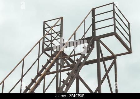 Verlassene Metallturm Fragment mit Geländer und Treppe ist unter Bewölktes Himmel am Tag Stockfoto