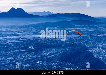 Paragliding über Salzburg in Österreich, Europa. Gleitschirm, gestartet vom 1287 Meter hohen Gaisberg, mit Blick auf die Hauptstadt Salzburg. Stockfoto