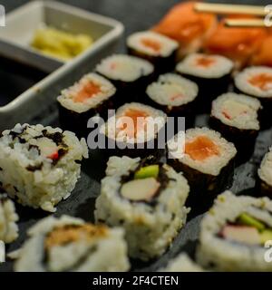 Schwarzes Schiefertablett mit verschiedenen Sushi-Stücken Stockfoto