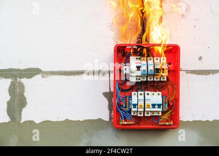 Brennende Schalttafel vor Überlastung oder Kurzschluss an der Wand Stockfoto