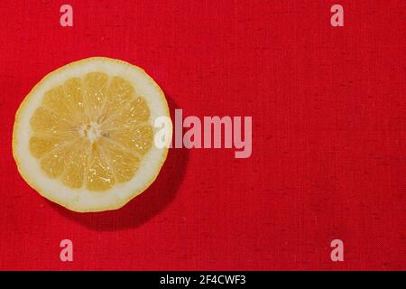 Detail von frischen Zitronenscheiben auf einem rustikalen Leinwandstoff Textur in rot gewebter Farbe Stockfoto
