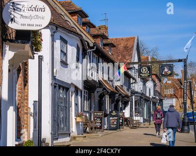 Pinner Village High Street. Historisches Queen's Head Pub, Fridolin's Beauty Clinic, Pizza Express Old Village Bäckerei Gebäude. Leute, die auf der Straße laufen. Stockfoto