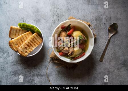 Hühnereintopf und Gemüse in einer Schüssel und Brotscheiben Stockfoto