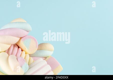Marshmallows bunte Kaubonbons auf blauem Hintergrund. Sweet Holiday Food Konzept. Stockfoto