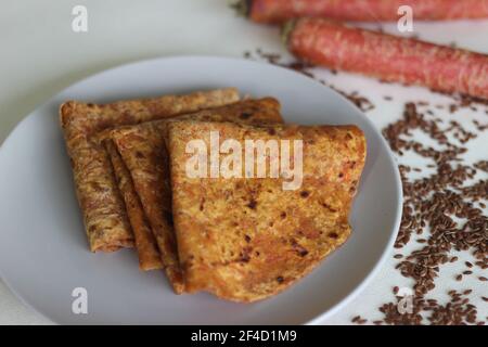 Karotte Leinsamen Paratha. Indisches Flachbrot aus Vollkorn, geriebenen Karotten und gemahlenen Leinsamen. Aufnahme auf weißem Hintergrund Stockfoto