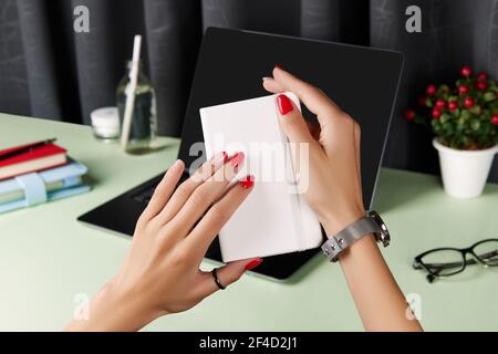 Schöne gepflegte Frauen Hände über grünen Tisch. Damen Sommer Accessoires Stockfoto