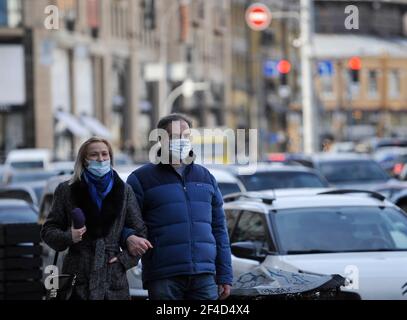 Kiew, Ukraine. März 2021, 19th. Ein Paar mit Gesichtsmasken als Vorsichtsmaßnahme gegen die Ausbreitung des Coronavirus spaziert während der Coronavirus-Krise in der Innenstadt auf der Straße.in der Ukraine wurden täglich 15 292 neue Fälle von Coronavirus-Infektion bestätigt. Eine komplexe epidemiologische Situation wird in den Regionen Tscherniwzi, Schytomyr, Iwano-Frankiwsk, Zakarpatska sowie in den Regionen Odessa und Kiew verzeichnet. Ab heute, dem 20. März, werden die Quarantänebeschränkungen in Kiew durch die Entscheidung der lokalen Behörden verschärft. Kredit: Sergei Chuzavkov/SOPA Images/ZUMA Wire/Alamy Live Nachrichten Stockfoto