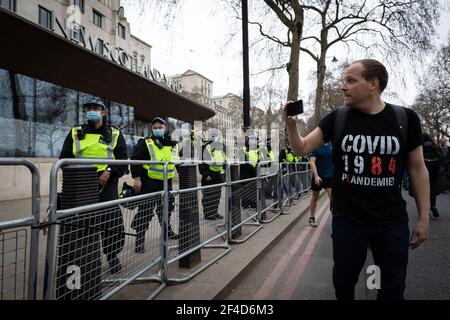 London, Großbritannien. März 2021, 20th. Ein Protestler geht bei einem Sperrprotest an Scotland Yard vorbei. Die Sperre wurde implementiert, um die Ausbreitung von COVID-19 zu stoppen. Ein Jahr nach der Einführung von Lockdowns wird eine World Wide Rally for Freedom organisiert. Kredit: Andy Barton/Alamy Live Nachrichten Stockfoto