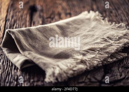 Flachs- oder Jute-Rustikal-Lappen auf dunklem Holztisch gefaltet. Stockfoto