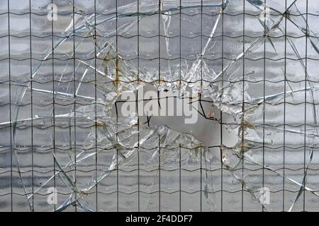 Zerbrochenes Sicherheitsglas mit großer Lochbeschädigung Stockfoto