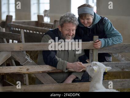 Roskow, Deutschland. März 2021, 15th. Die Bäuerin Katja Behling und ihr Mann Christoph (gelernter Hirte) streicheln in der Scheune auf dem Skudden-Hof im Weseram-Bezirk Roskow ein geschorntes Mutterschafe der Skudden-Rasse. Auf ihrem Hof züchten die Paare Skudden, die kleinste einheimische Schafrasse, die eine der ältesten Hausschafrassen ist und weiße Mischwolle produziert. Die Skudde ist auf der Roten Liste der gefährdeten Tierrassen. Quelle: Soeren Stache/dpa-Zentralbild/ZB/dpa/Alamy Live News Stockfoto