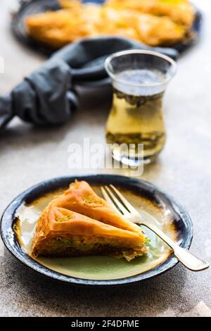 Nahaufnahme einer Scheibe Baklava mit einem Glas Tee Stockfoto