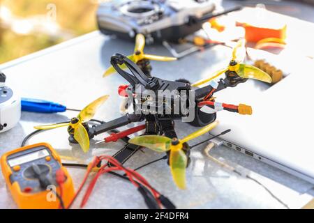 Ein fpv-Hochgeschwindigkeits-Drohnenkopter und Fernsteuergerät für die Telemetrie Auf dem Tisch liegen Stockfoto