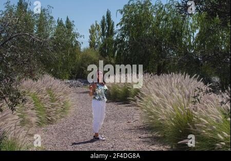 Lächelnde Frau, die in einem Garten mit einem Glas Champagner steht, Mendosa, Argentinien Stockfoto