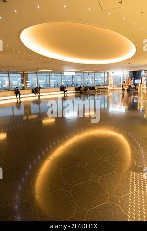 Sitzbereich im Haneda Tokyo International Airport mit Spiegelung der Deckenleuchten, Japan Stockfoto