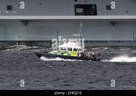 MDP Jura, ein vom Verteidigungsministerium der Polizei betriebener Start der Inselklasse, wird hier nach dem ersten Besuch des Flugzeugträgers der Royal Navy, HMS Queen Elizabeth (R08), auf dem Clyde gesehen. Stockfoto