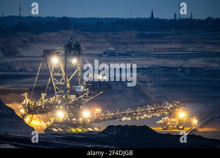 Jackerath, Deutschland. März 2021, 20th. Kurz nach Sonnenuntergang bahnt sich ein riesiger Bagger seinen Weg durch den Boden im Tagebau Garzweiler von RWE-Power. Die umstrittene Braunkohletagebau ist ein wiederkehrendes Thema der politischen Debatte. Quelle: Boris Roessler/dpa/Alamy Live News Stockfoto