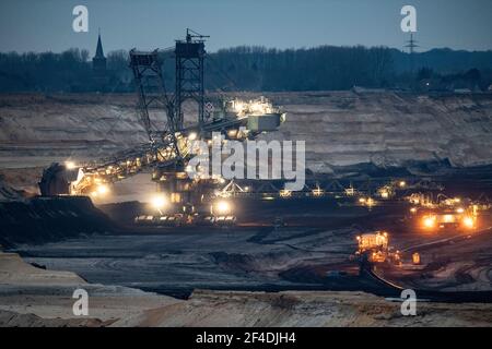 Jackerath, Deutschland. März 2021, 20th. Kurz nach Sonnenuntergang bahnt sich ein riesiger Bagger seinen Weg durch den Boden im Tagebau Garzweiler von RWE-Power. Die umstrittene Braunkohletagebau ist ein wiederkehrendes Thema der politischen Debatte. Quelle: Boris Roessler/dpa/Alamy Live News Stockfoto