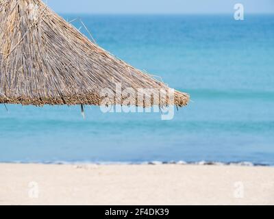 Sommerlandschaft mit Strohschirmen am Strand in Mangalia oder Mamaia. Strand am Schwarzen Meer in Rumänien. Stockfoto
