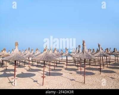 Sommerlandschaft mit Strohschirmen am Strand in Mangalia oder Mamaia. Strand am Schwarzen Meer in Rumänien. Stockfoto