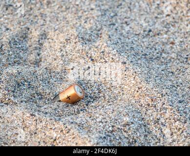 Unsachgemäß entsorgt Batterien im Sand am Strand.Altbatterien. Konzept der Umweltverschmutzung. Stockfoto