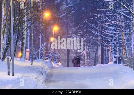Schneebedeckte Fußgängerstraße im Wohnviertel nach einem Schneesturm am Morgen oder Abend in Finnland. Stockfoto