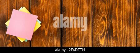Leere bunte Aufkleber auf braunem Holztisch. Stockfoto
