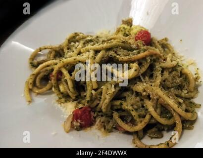 Grüne Spaghetti Pasta Tagliatelle mit braunen Shimeji Pilzen und Parmesan Käse auf der Oberseite serviert auf einem weißen Teller in italienischer Sprache Restaurant Stockfoto