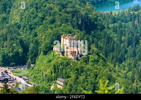 Luftaufnahme der Burg Hohenschwangau auf der Bergspitze, Deutschland, Europa. Alpenlandschaft mit deutschem Schloss Hohenschwangau wie Palast im Sommerwald Stockfoto
