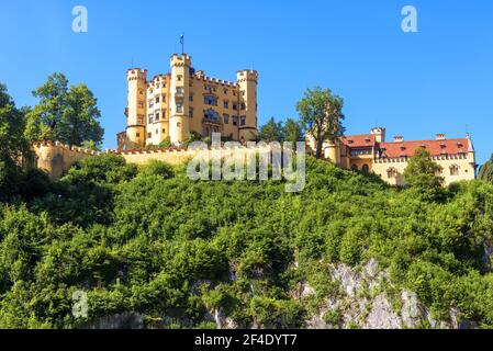 Schloss Hohenschwangau auf der Bergspitze, Deutschland. Schloss Hohenschwangau ist ein berühmtes Wahrzeichen der bayerischen Alpen. Landschaftlich schöne Aussicht auf alte deutsche Burg, Palast o Stockfoto