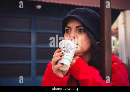 Eine Frau in Rot trinkt Kaffee Stockfoto