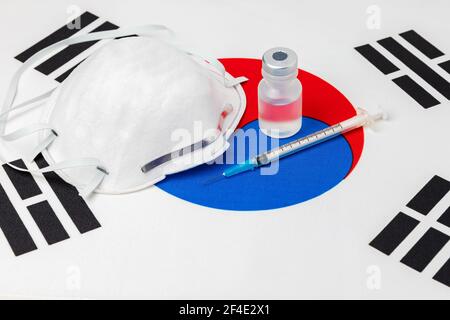 Südkorea Flagge, N95 Gesichtsmaske, Nadelspritze und Fläschchen. Konzept der Covid-19 Coronavirus-Impfstoffverteilung, Versorgungsengpässe und Gesundheitskrise Stockfoto