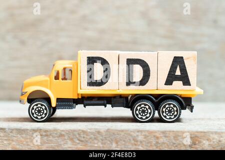 Spielzeug-LKW halten Alphabet Buchstabenblock in Wort DDA (Abkürzung von Abschreibung, Erschöpfung und Abschreibung oder Nachfrage-Einlagenkonto) auf Holz-Backgrou Stockfoto